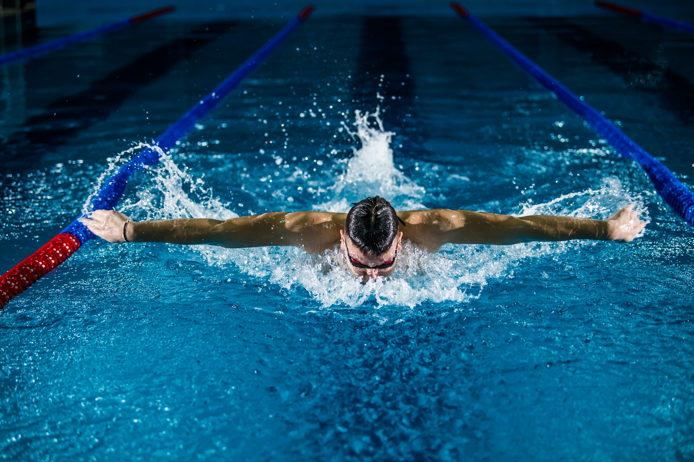 Swimmer training butterfly stroke in a pool lane